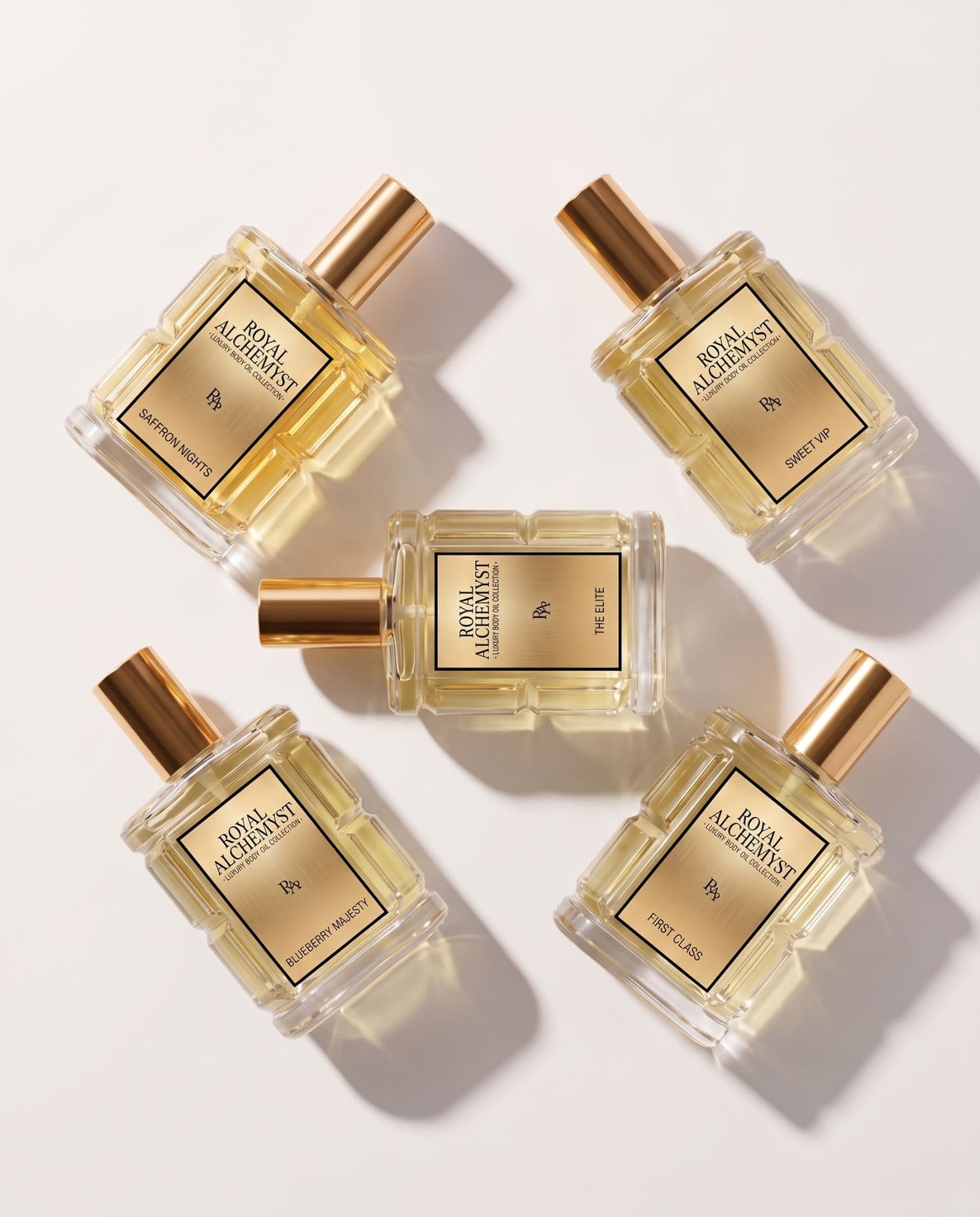 Five Royal Alchemyst luxury body oil bottles arranged on a cream surface in warm light
